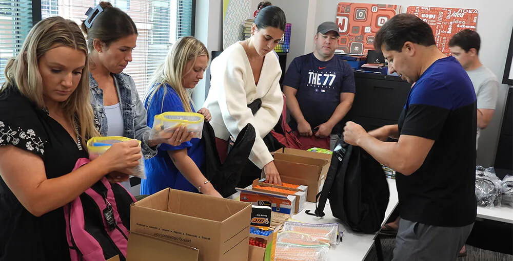 The Pepper Group team packing backpacks for kids